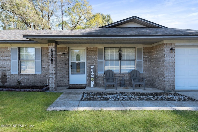 single story home with a front yard, covered porch, and a garage