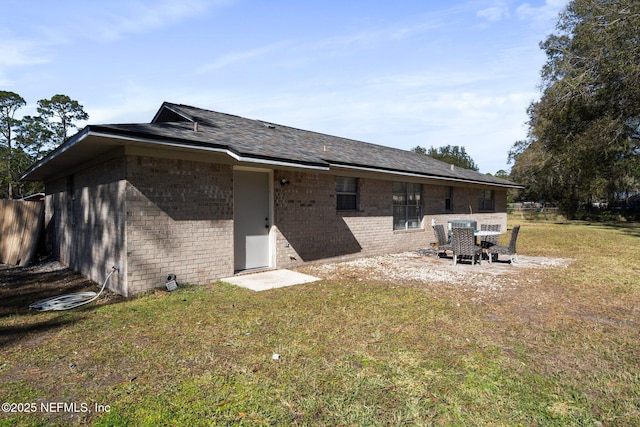 back of property featuring a patio area and a lawn