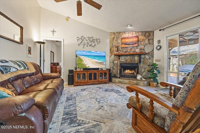 living room with ceiling fan, a stone fireplace, a textured ceiling, and lofted ceiling