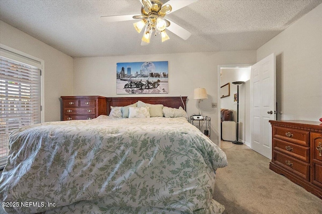 carpeted bedroom with ceiling fan and a textured ceiling