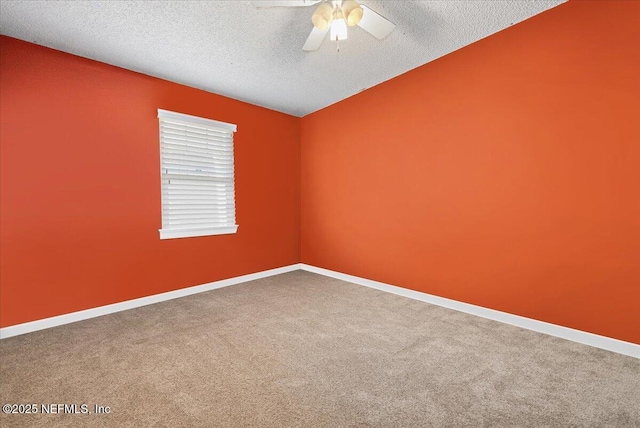 spare room with a textured ceiling, carpet flooring, and ceiling fan