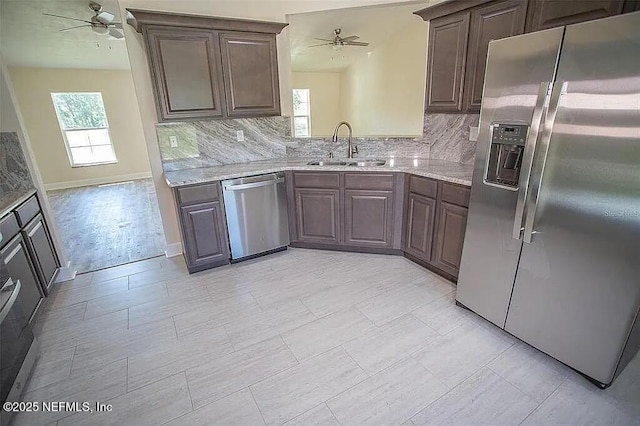 kitchen with appliances with stainless steel finishes, tasteful backsplash, a wealth of natural light, and sink