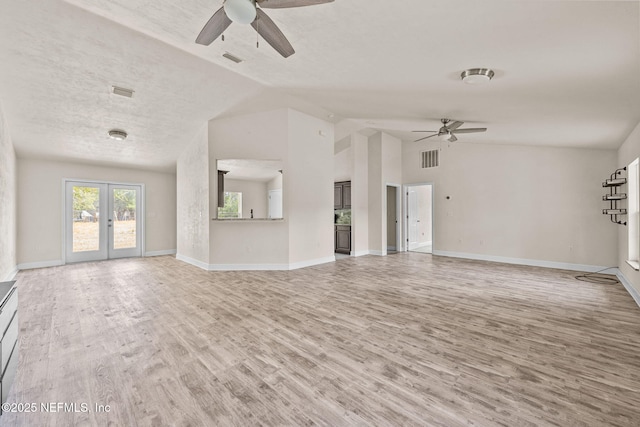 unfurnished living room with french doors, vaulted ceiling, a textured ceiling, hardwood / wood-style flooring, and ceiling fan