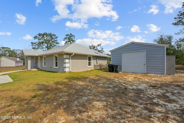 rear view of house with a garage, a yard, and an outdoor structure