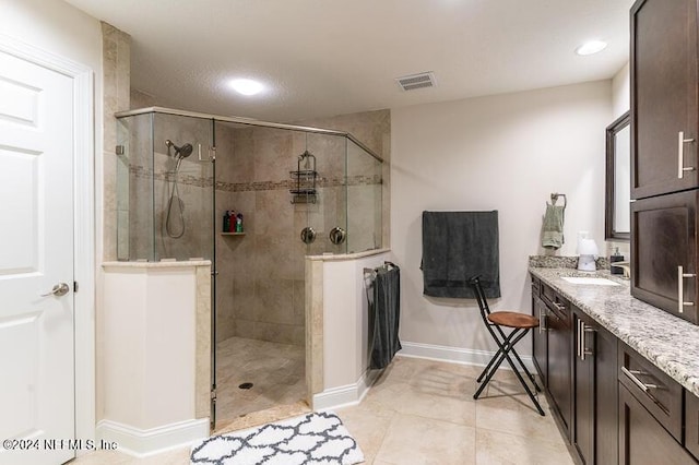 bathroom with tile patterned flooring, walk in shower, and vanity