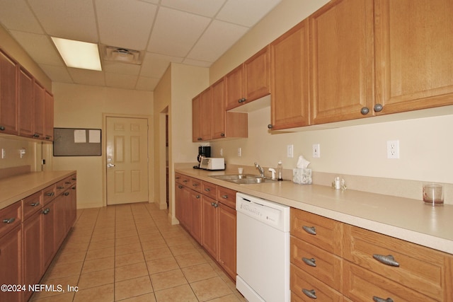 kitchen featuring sink, dishwasher, light tile patterned flooring, and a drop ceiling