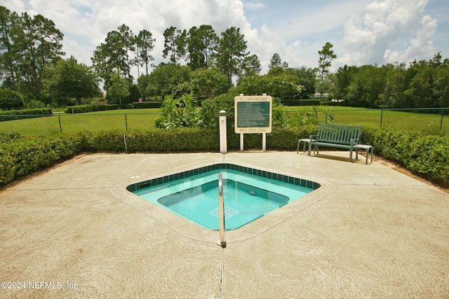 view of swimming pool with a hot tub