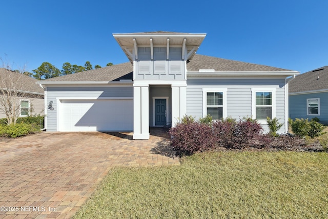 view of front of property featuring a front yard and a garage