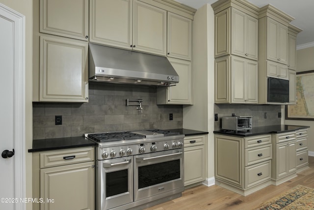 kitchen with light hardwood / wood-style flooring, double oven range, cream cabinetry, backsplash, and ornamental molding