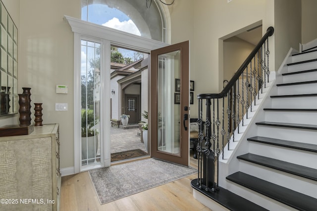 foyer with a high ceiling and light hardwood / wood-style flooring