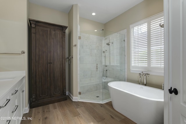 bathroom featuring shower with separate bathtub, vanity, and hardwood / wood-style floors