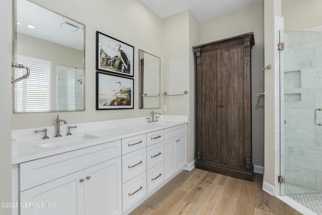 bathroom featuring a shower with door, hardwood / wood-style floors, and vanity