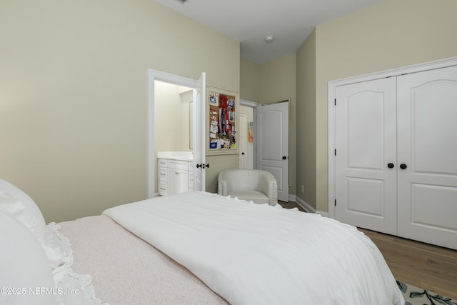 bedroom featuring ensuite bath, a closet, and hardwood / wood-style floors