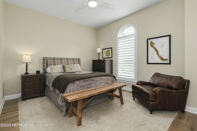 bedroom featuring ceiling fan, light hardwood / wood-style floors, and multiple windows