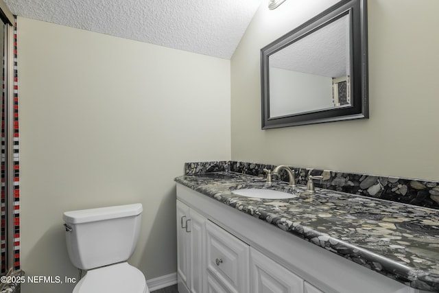 bathroom featuring toilet, vanity, a textured ceiling, and vaulted ceiling