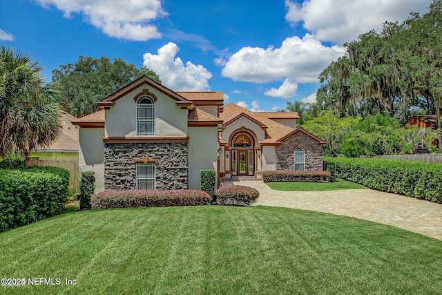 mediterranean / spanish house featuring a front lawn