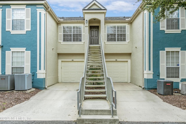 view of property featuring a garage and central AC unit