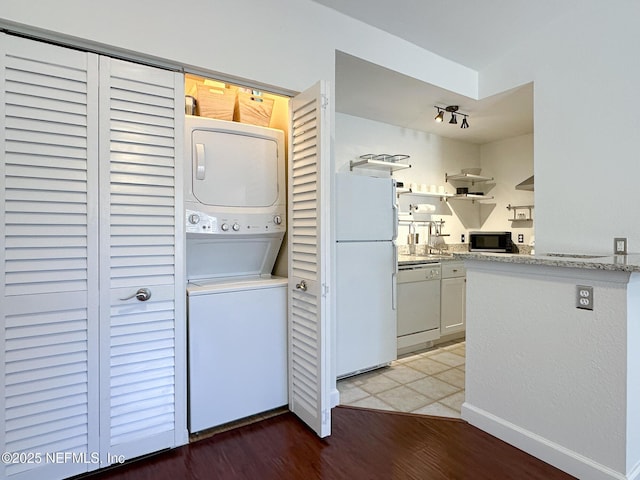 laundry area with stacked washer / dryer and hardwood / wood-style floors