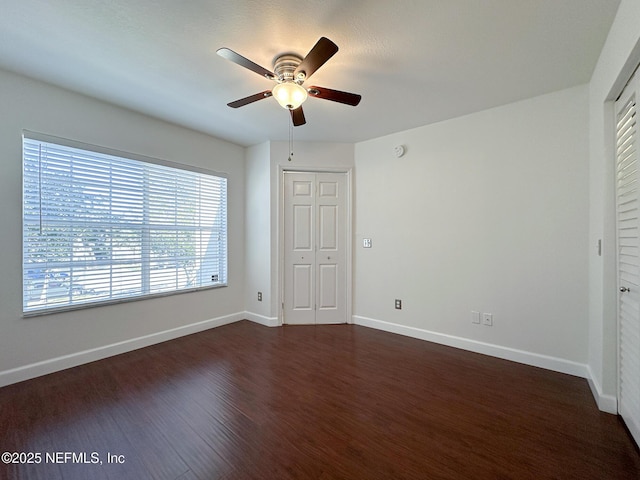 unfurnished bedroom with a closet, ceiling fan, and dark hardwood / wood-style floors