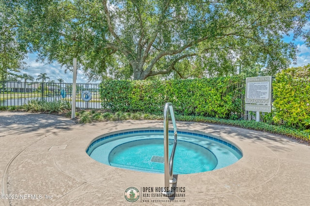 view of swimming pool with a hot tub