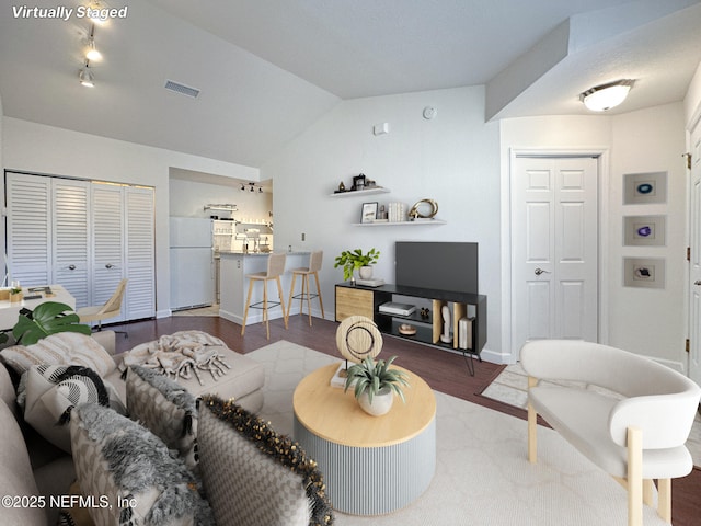 living room with vaulted ceiling and hardwood / wood-style flooring