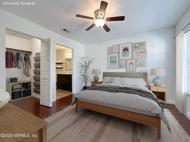 bedroom featuring a walk in closet, wood-type flooring, a closet, ceiling fan, and ensuite bathroom