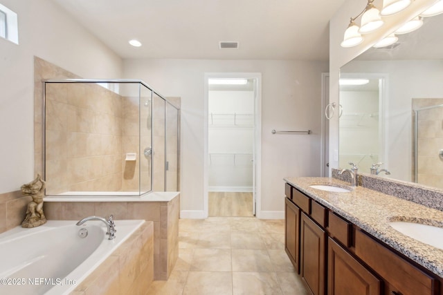 bathroom featuring tile patterned flooring, shower with separate bathtub, and vanity