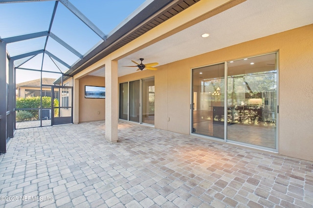 view of patio / terrace featuring ceiling fan and glass enclosure