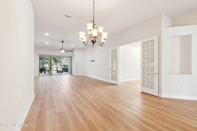 unfurnished living room with light wood-type flooring, ceiling fan with notable chandelier, and french doors