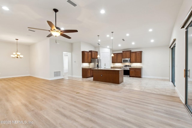 kitchen featuring stainless steel appliances, light hardwood / wood-style floors, a kitchen island, and decorative light fixtures