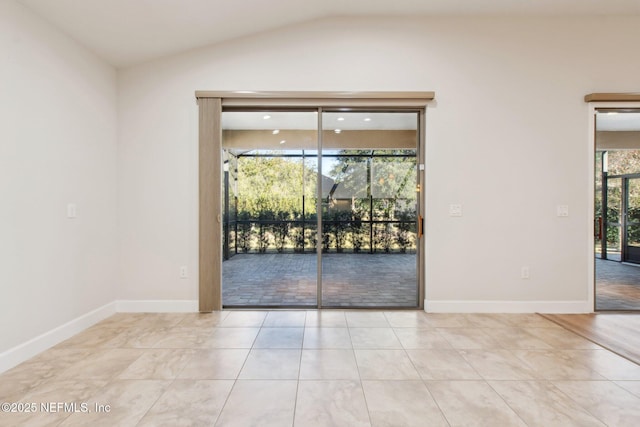 tiled spare room featuring vaulted ceiling and plenty of natural light