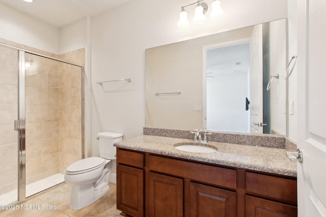 bathroom with toilet, vanity, tile patterned flooring, and a shower with shower door