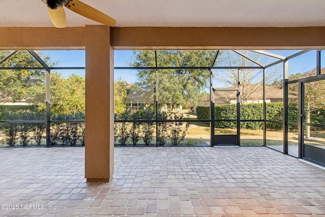 unfurnished sunroom featuring ceiling fan