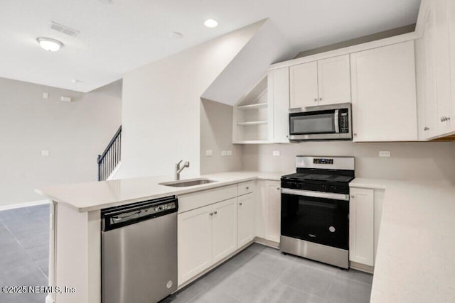 kitchen featuring white cabinets, stainless steel appliances, sink, and kitchen peninsula