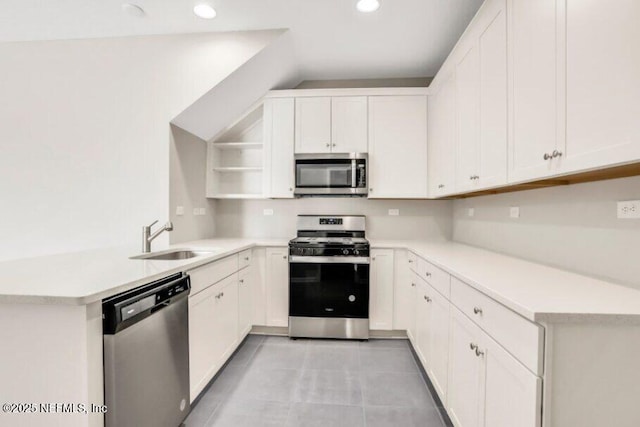 kitchen with stainless steel appliances, light tile patterned flooring, white cabinetry, and sink