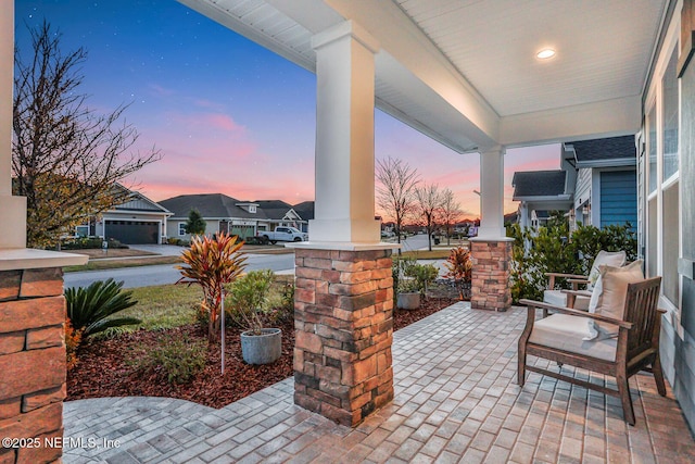 patio terrace at dusk featuring covered porch