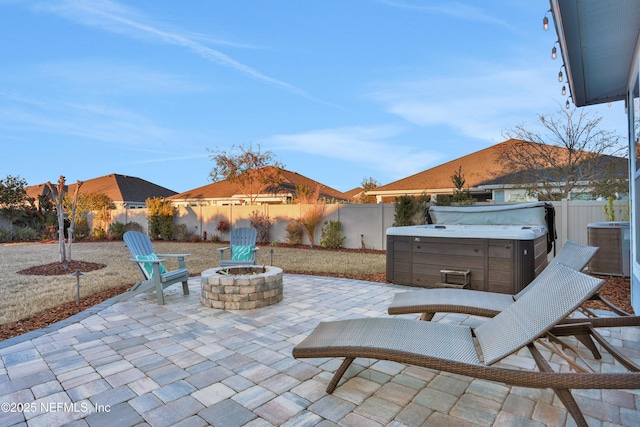 view of patio with an outdoor fire pit and a hot tub