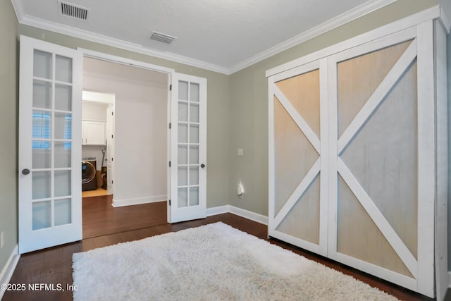 spare room with washer / dryer, dark hardwood / wood-style flooring, ornamental molding, and french doors