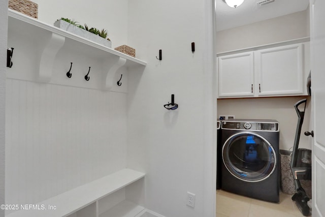 washroom featuring cabinets, light tile patterned floors, and washer / dryer