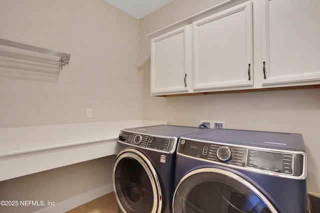 washroom featuring washer and dryer and cabinets