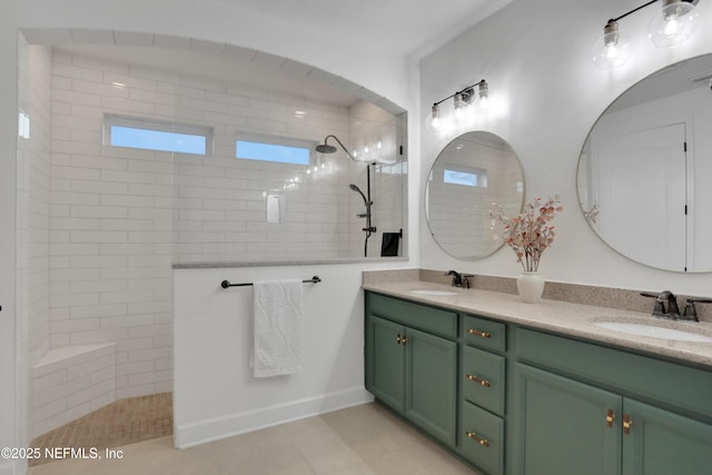 bathroom featuring vanity, tile patterned flooring, and a tile shower