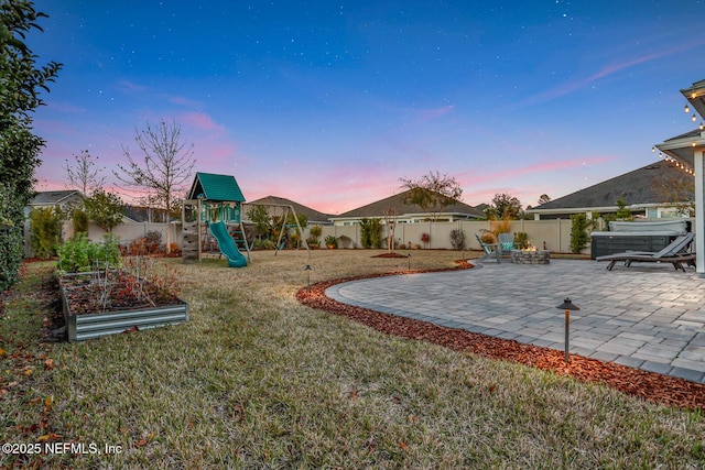 yard at dusk with a playground and a patio area