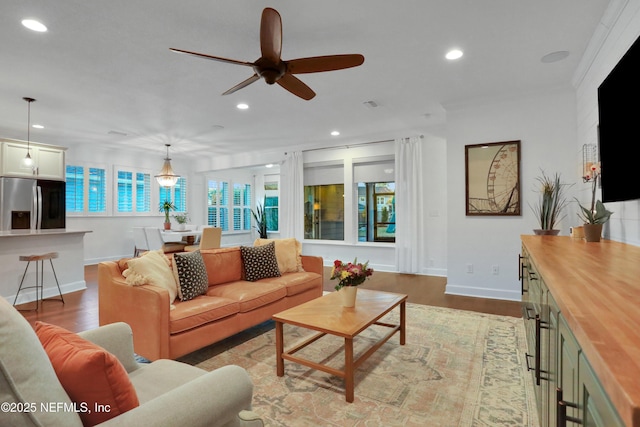 living room with ceiling fan, hardwood / wood-style floors, and crown molding