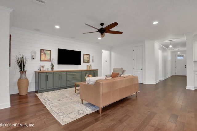 living room with ceiling fan, ornamental molding, and dark hardwood / wood-style floors