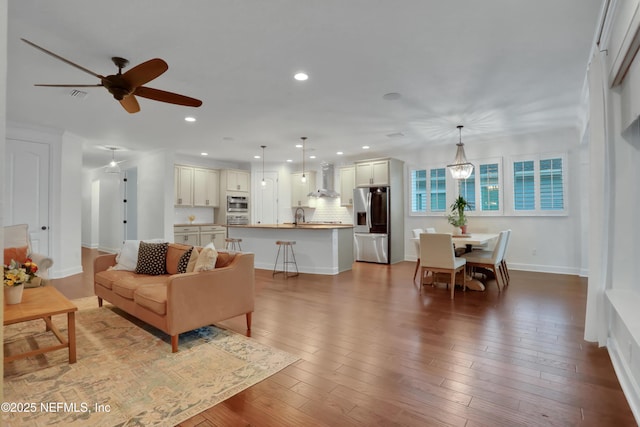 living room with ceiling fan, sink, and hardwood / wood-style floors