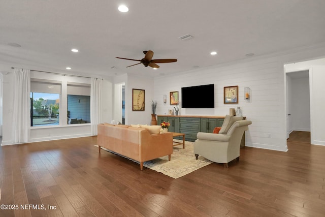 living room with ceiling fan, dark hardwood / wood-style flooring, and ornamental molding