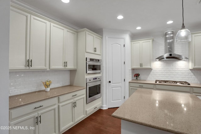 kitchen with stainless steel appliances, wall chimney exhaust hood, hanging light fixtures, and light stone countertops