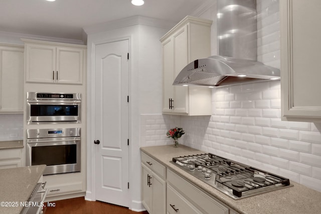 kitchen featuring light stone countertops, white cabinets, appliances with stainless steel finishes, exhaust hood, and backsplash