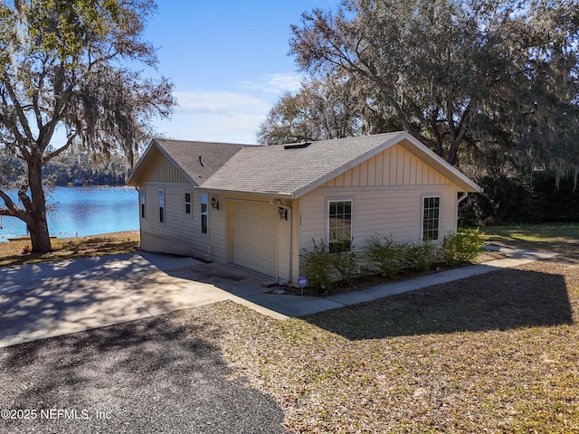 view of side of property with a garage and a water view