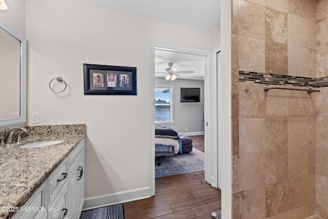 bathroom featuring a tile shower, ceiling fan, and vanity